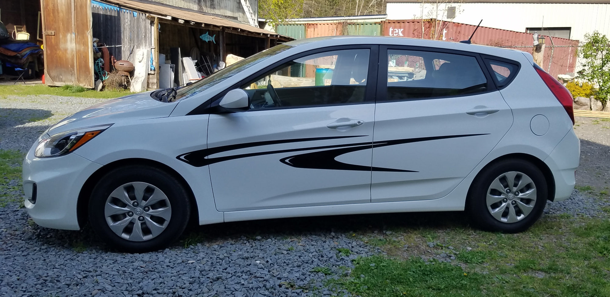 Black vinyl graphic stripes on the side of a small white hatchback car