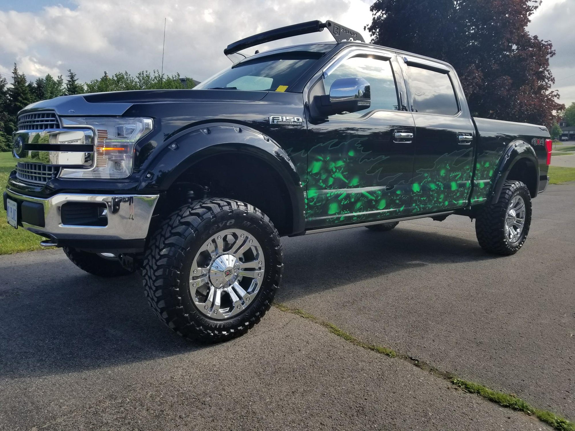 Neon green skulls wrap on the side of a black pick up truck