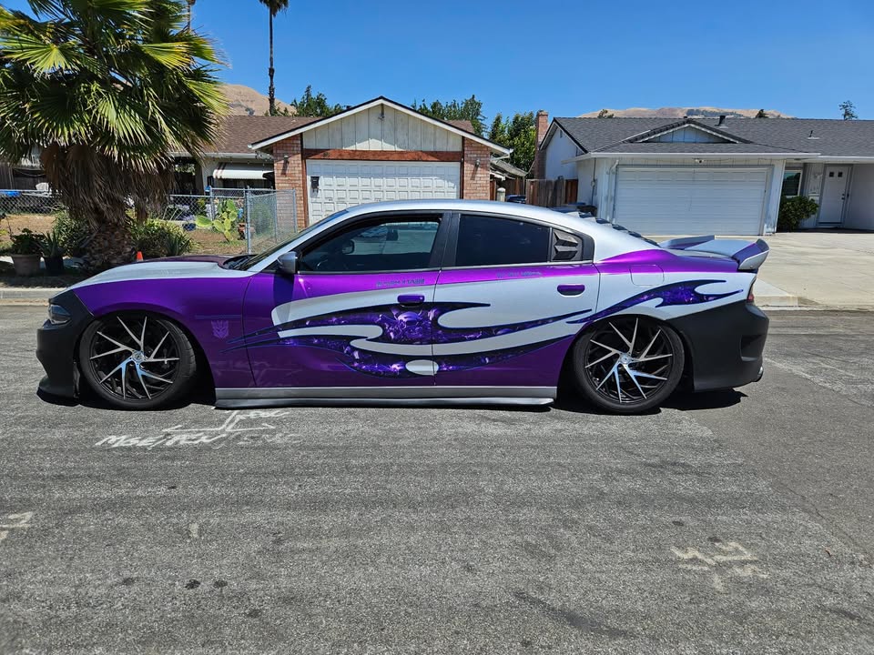 Modified sports car with purple and silver wrap and Tribal Chrome Skulls side decal