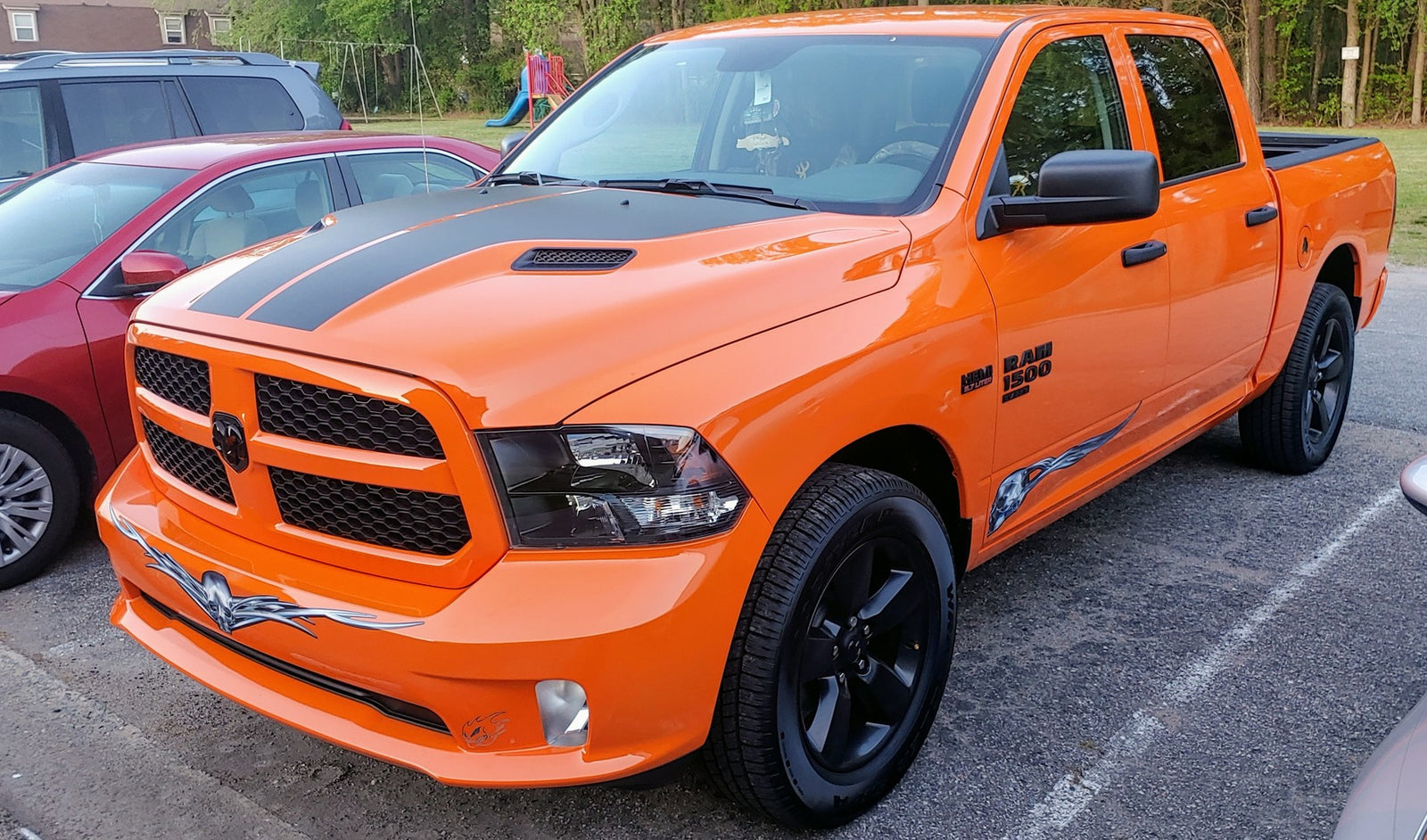 flying chrome skull vinyl graphics on bottom sides of orange dodge ram truck