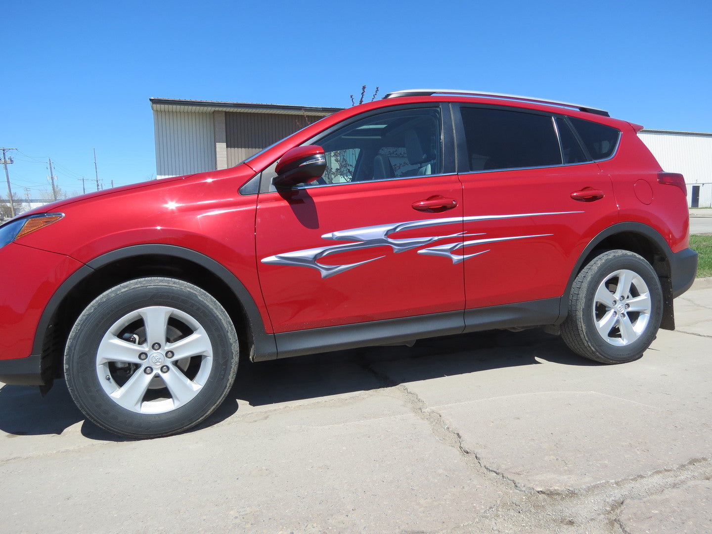 3D chrome effect stripe decals on the side of a red SUV parked outdoors