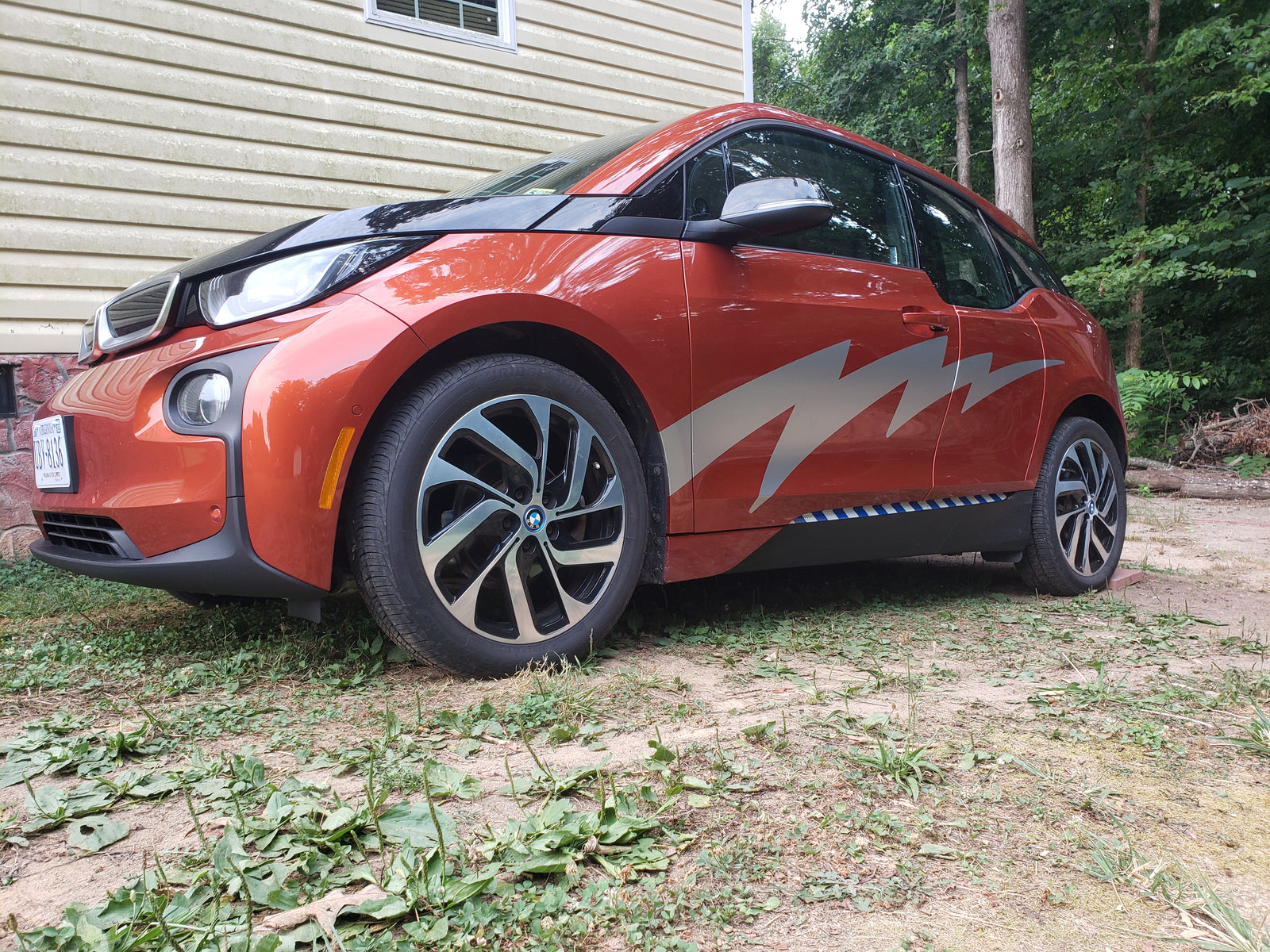 silver lightning vinyl decals on the side of a red BMW car