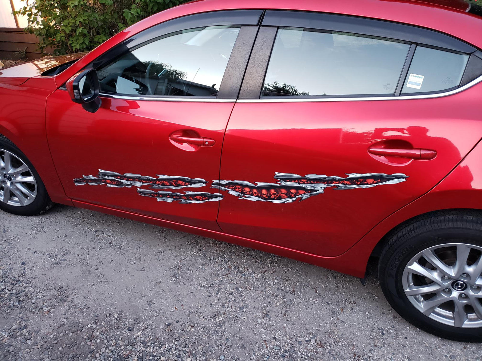 skulls tears vinyl graphics on the side of red car