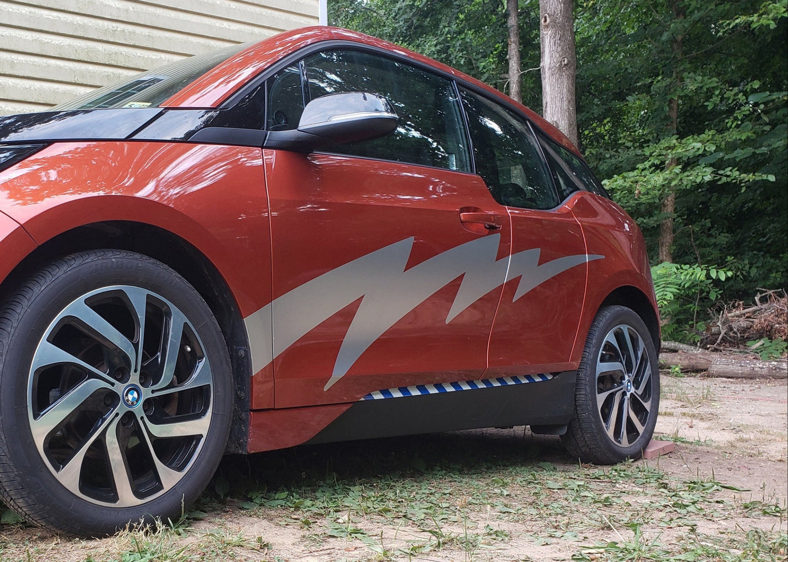 lightning bolt vinyl silver decal on the side of red bmw electric car