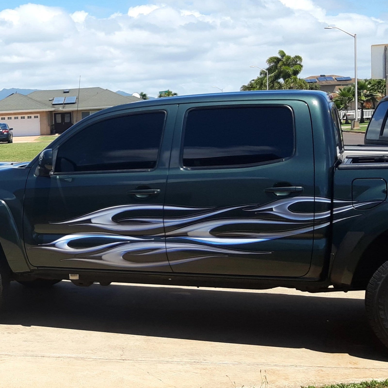 dark grey Toyota Tacoma truck with tribal chrome spear vinyl decals on driver side