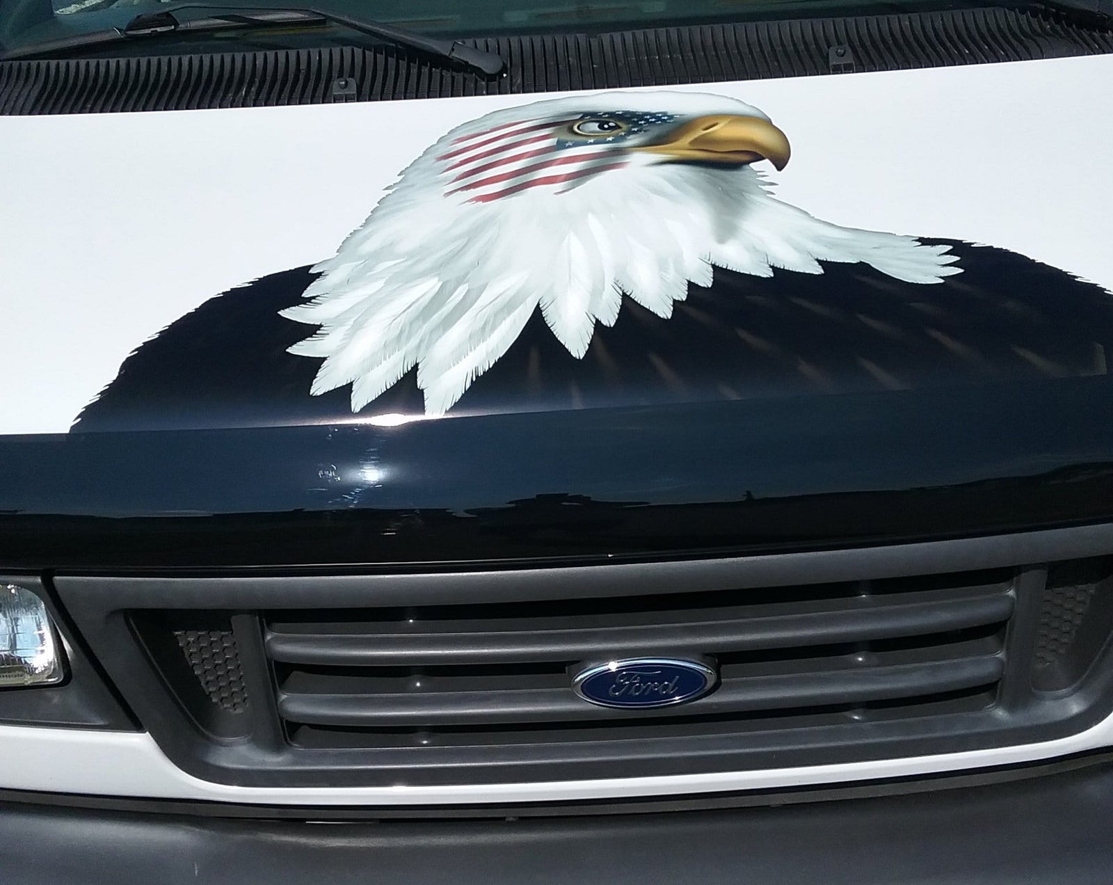 Ford van hood with large American bald eagle decal, American flag overlay across the eagle’s head and eye