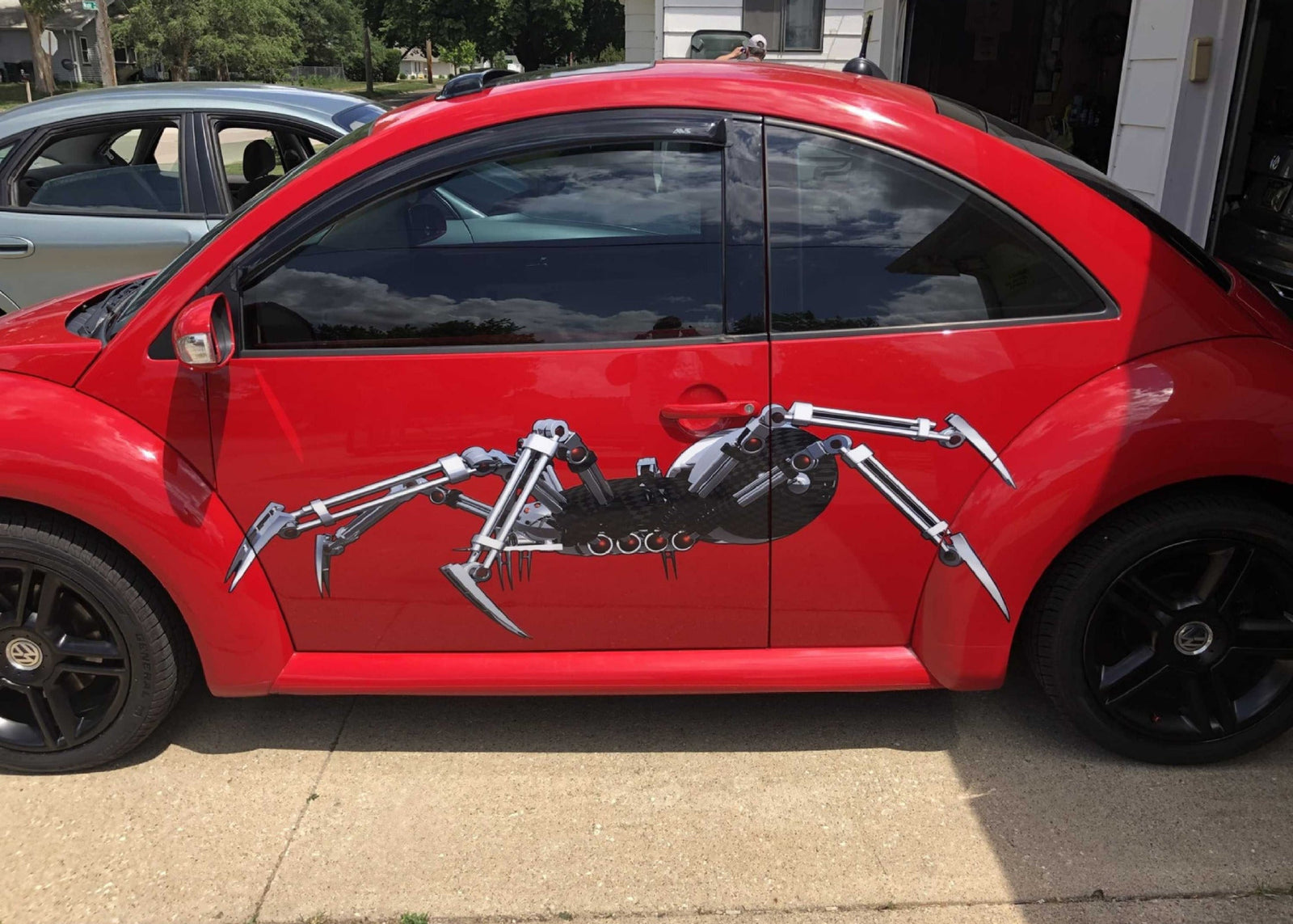 Robot spider decals on the side of red vw beetle car