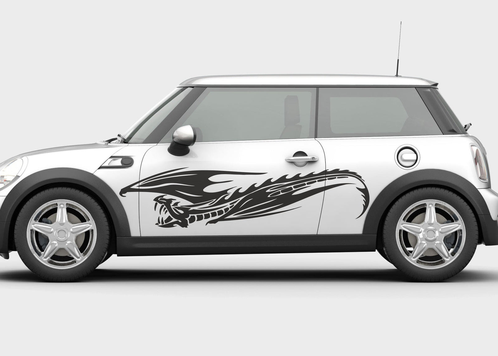 A car with a white body and a vinyl cut decal of a flying dragon graphic on the side door.