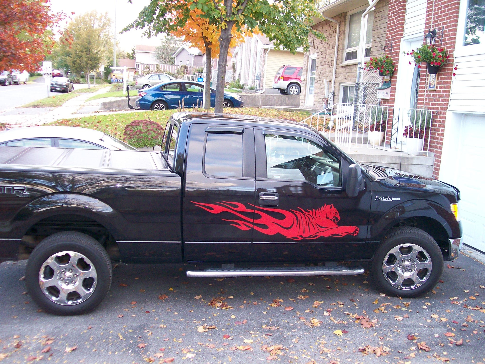 tiger flames red vinyl decal on the side of black f150 truck parked on the drive way