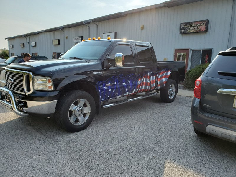 American flag wrap on the side of a black ford f350 truck