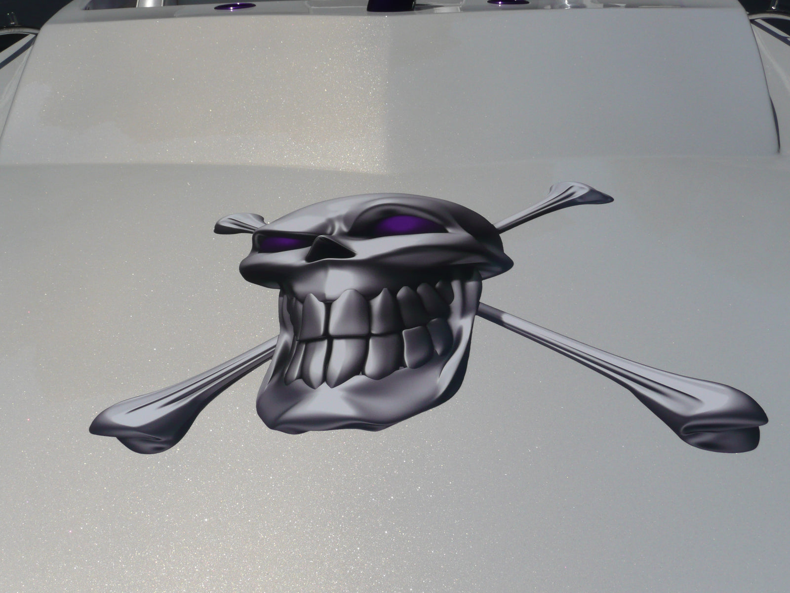 Chrome skull and crossbones on the front of white boat