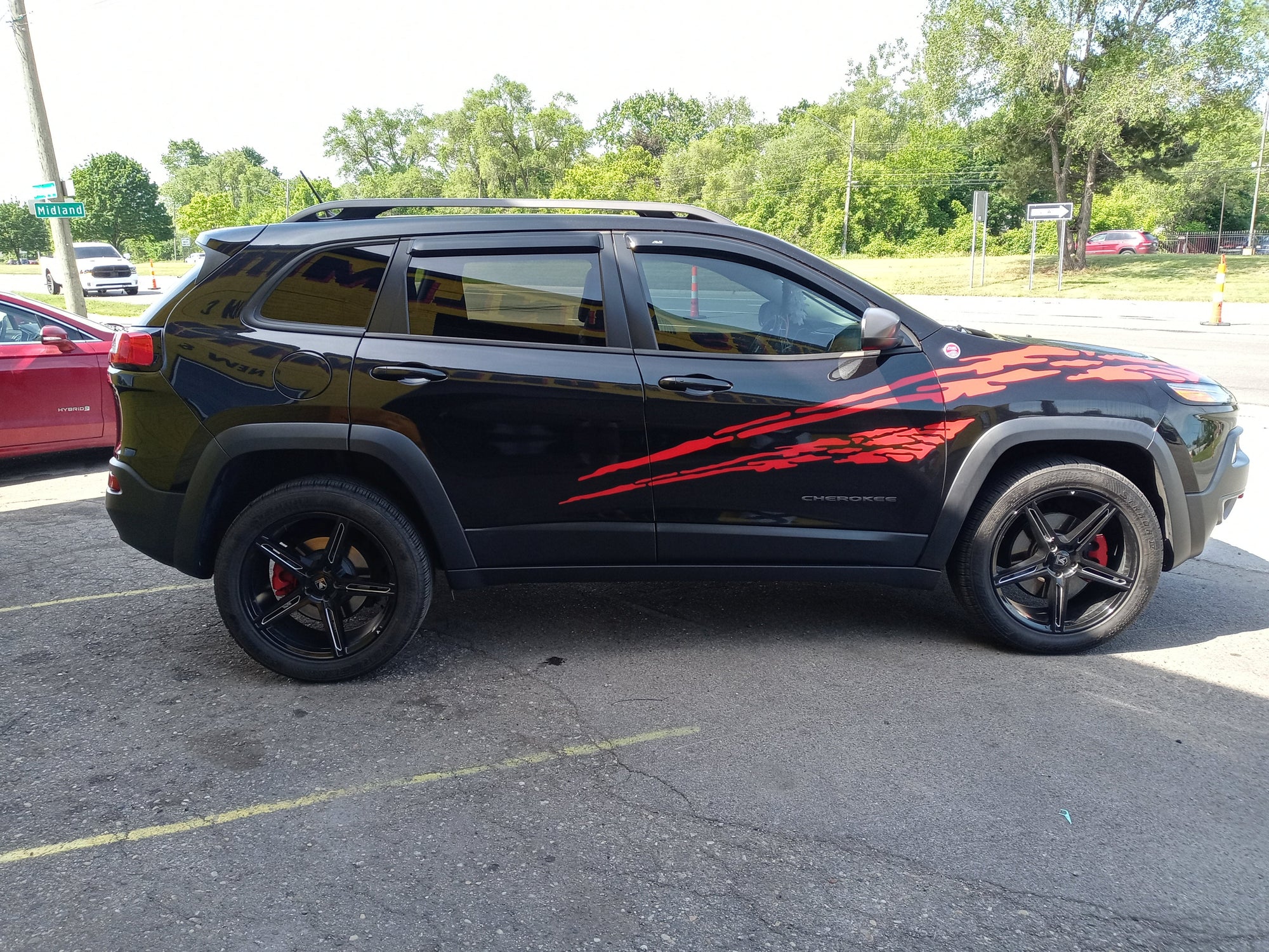 red vinyl cut splash decals on the side of a black Jeep Cherokee
