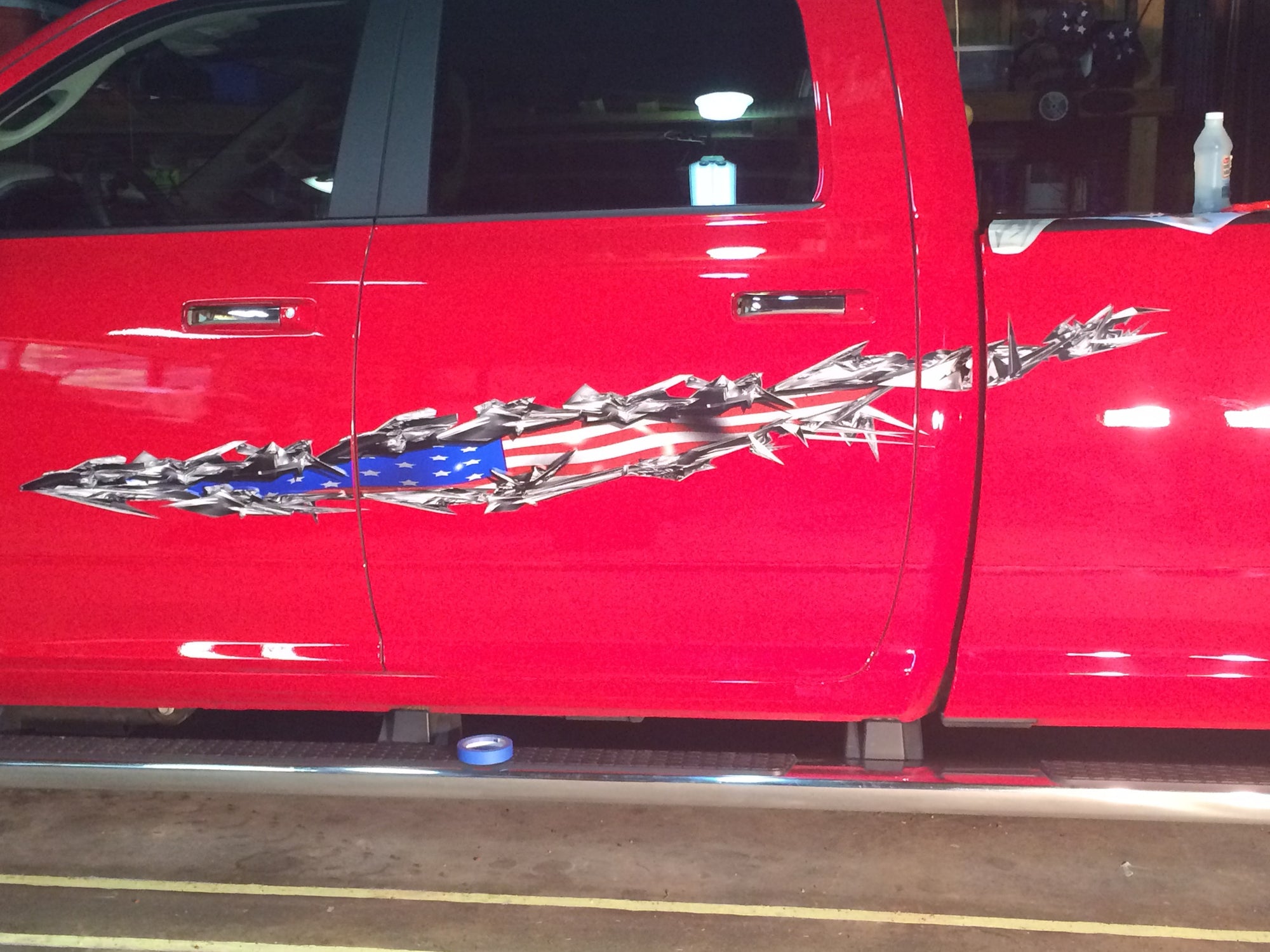 American flag tear side decals on red pickup truck