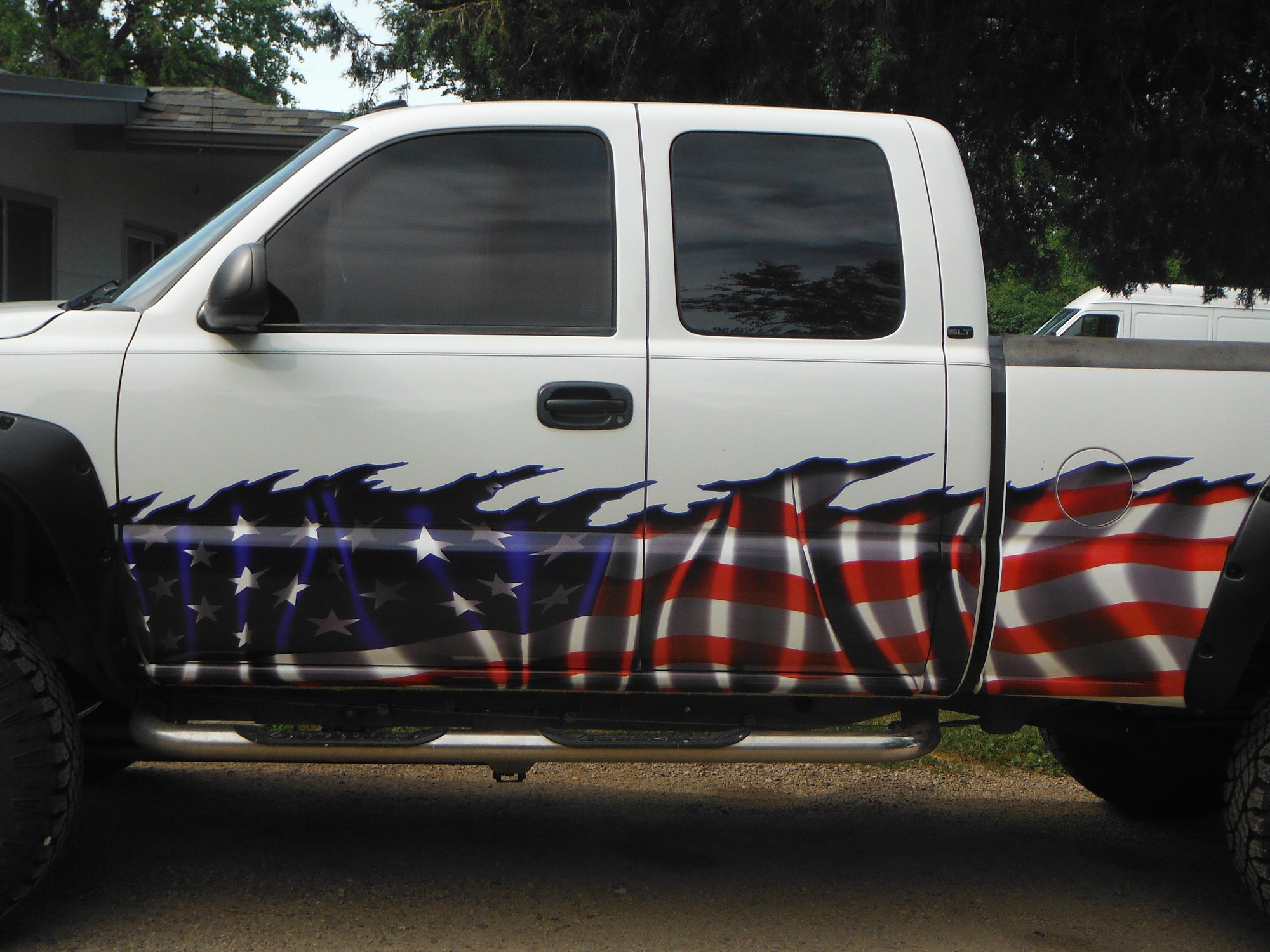 waving American flag decal on bottom half of white pick up truck