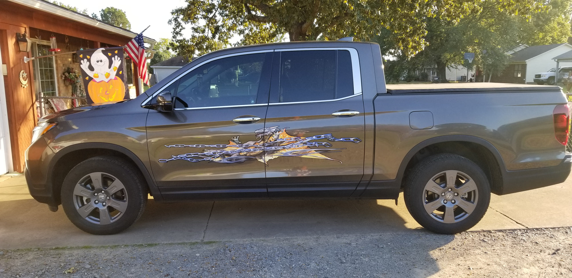 chained dragon decal on the side of a  honda ridgeline truck