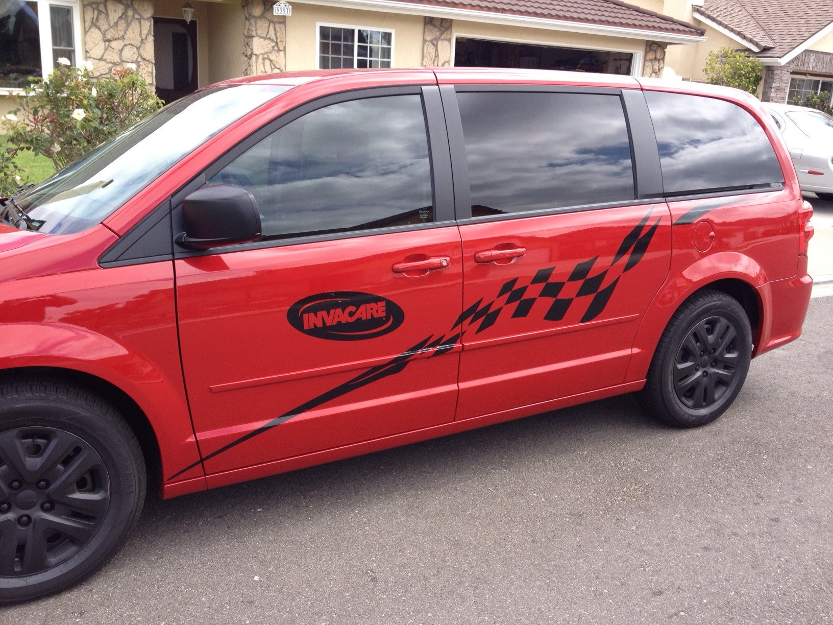 black checkered vinyl decal on the side of red mini van