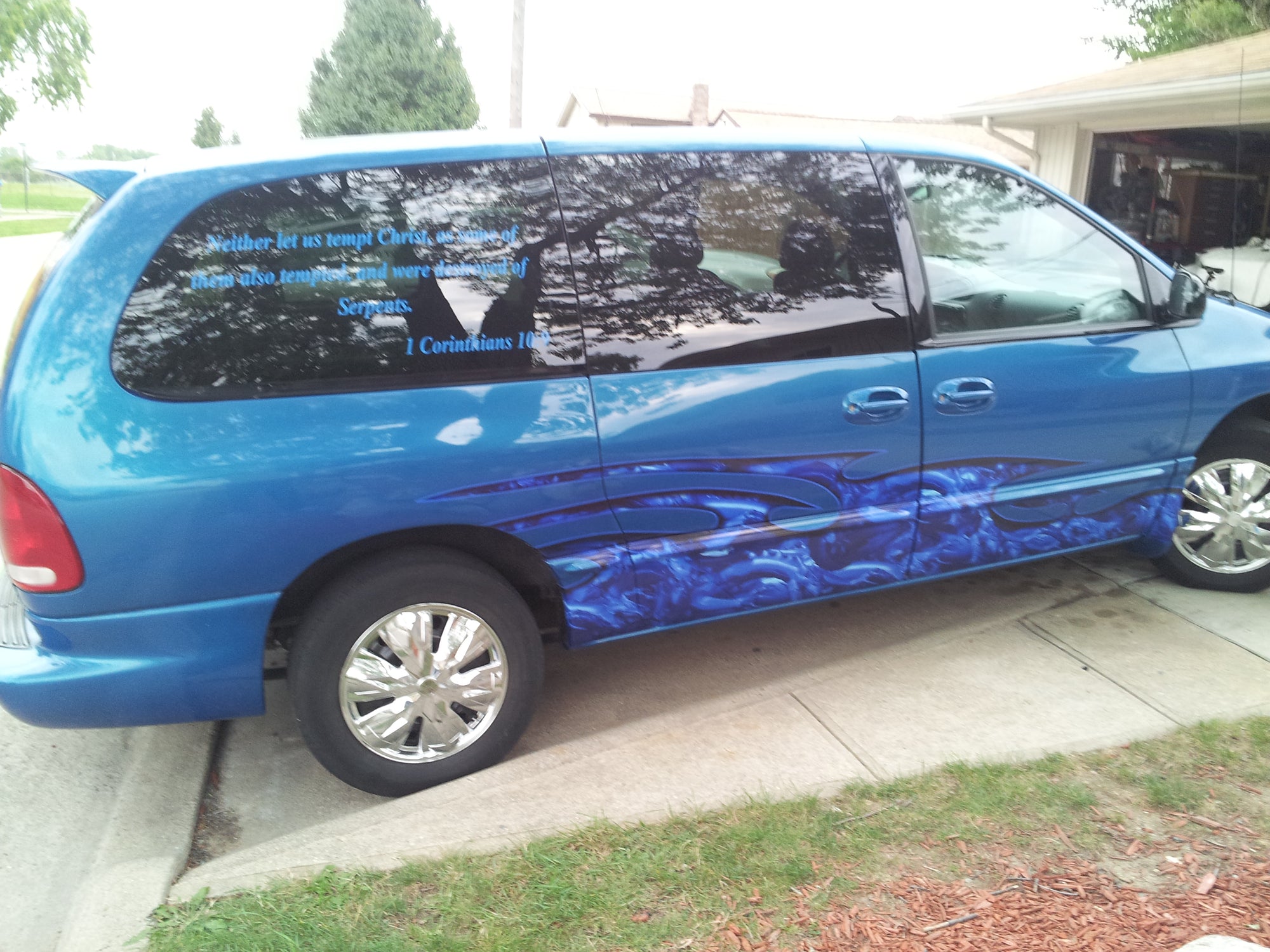 a wave of blue dragons half wrap decal on the bottom sides of a blue mini van