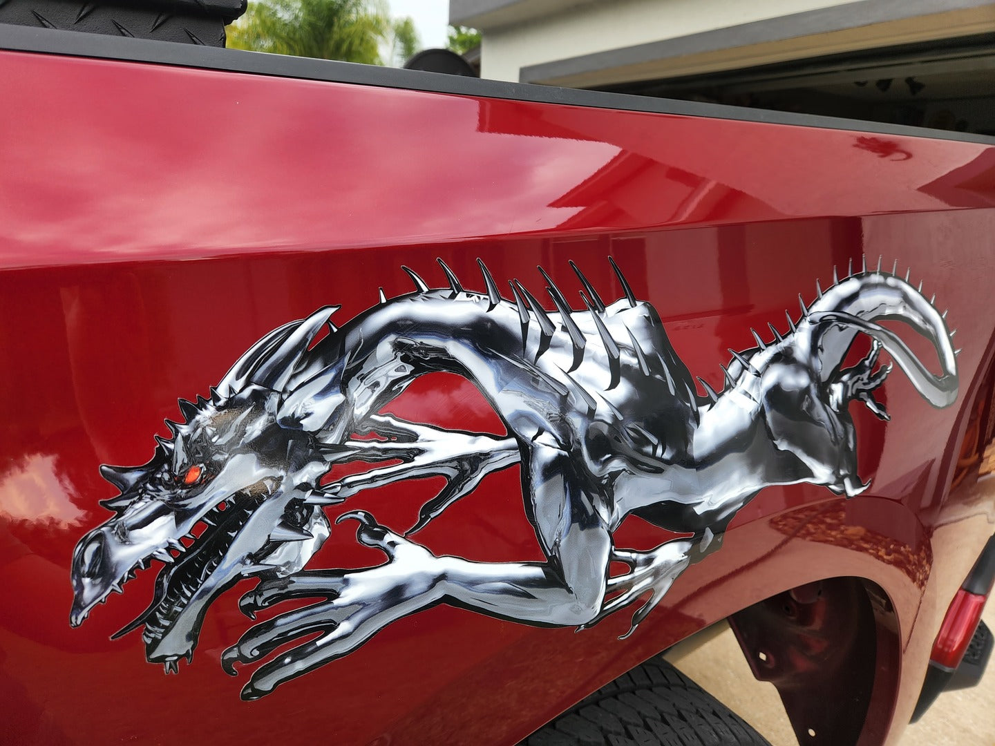chrome color dragon decal on the side of a red truck