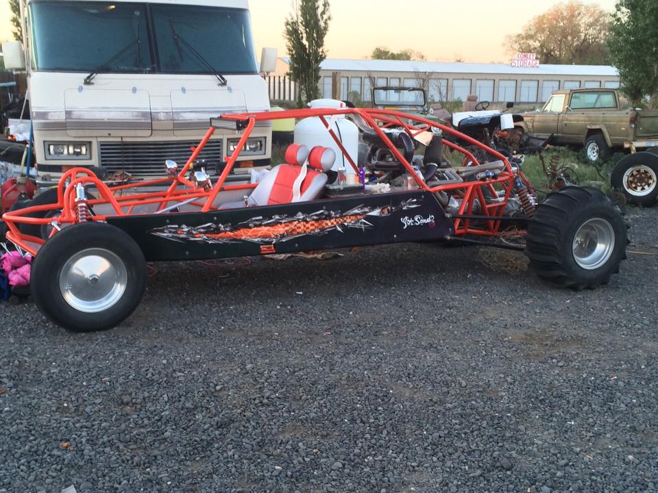 black and orange dune buggy with checkered tears decal on the side