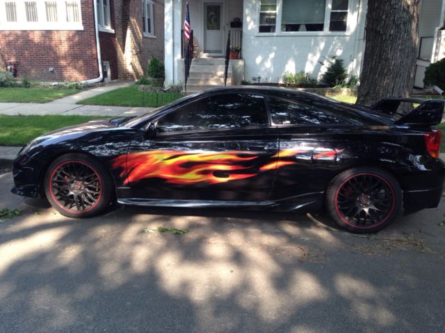 Full color fire flame decals on the side of a black Toyota Celica