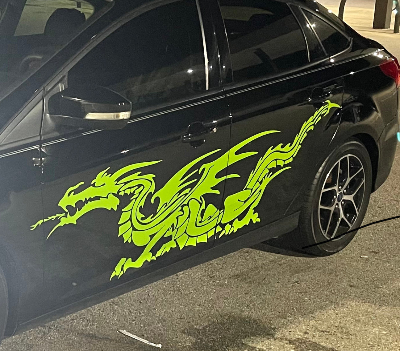 Green vinyl cut dragon decal on the side of black car
