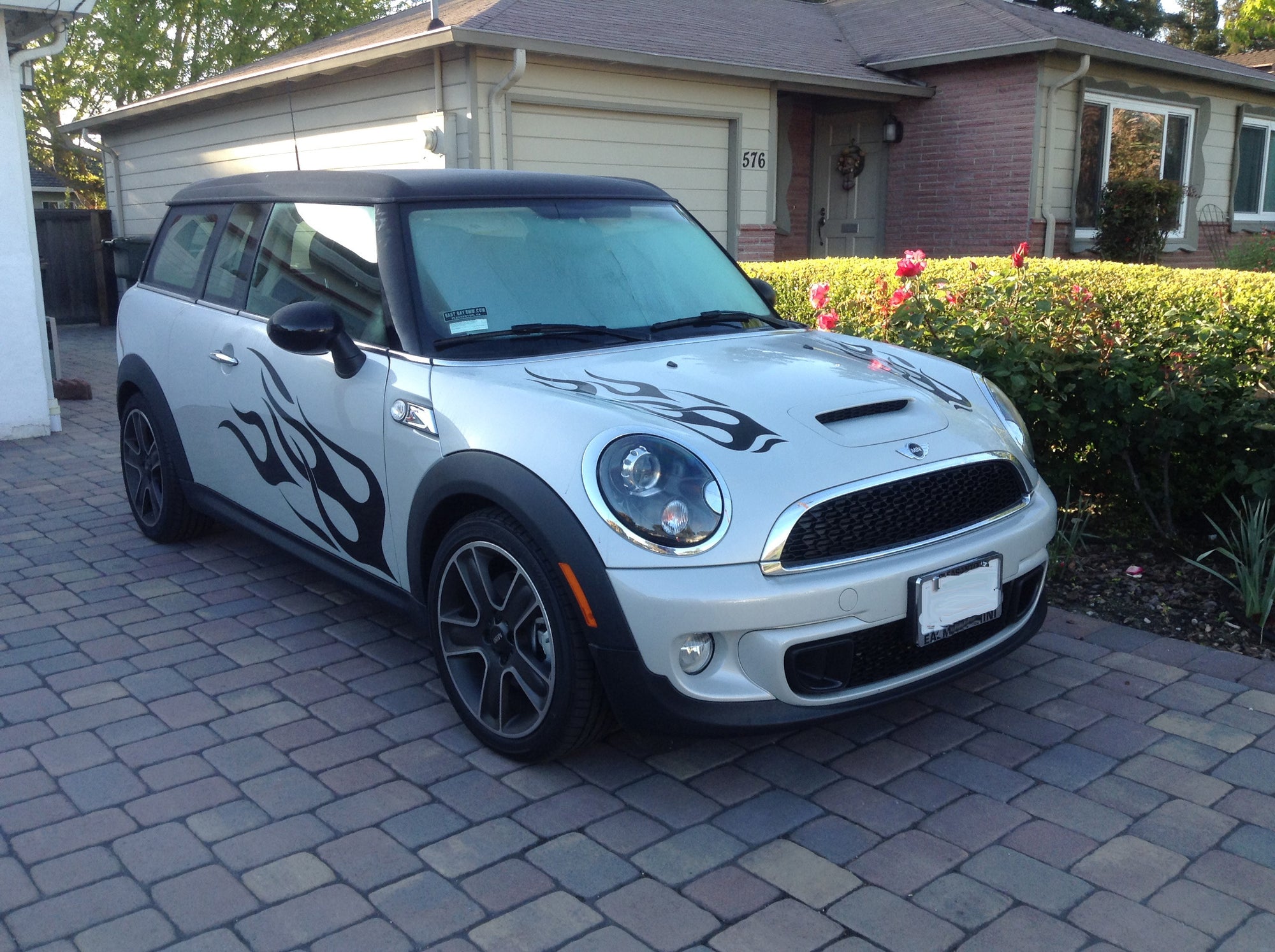 white mini cooper with black vinyl flame decals on sides and hood