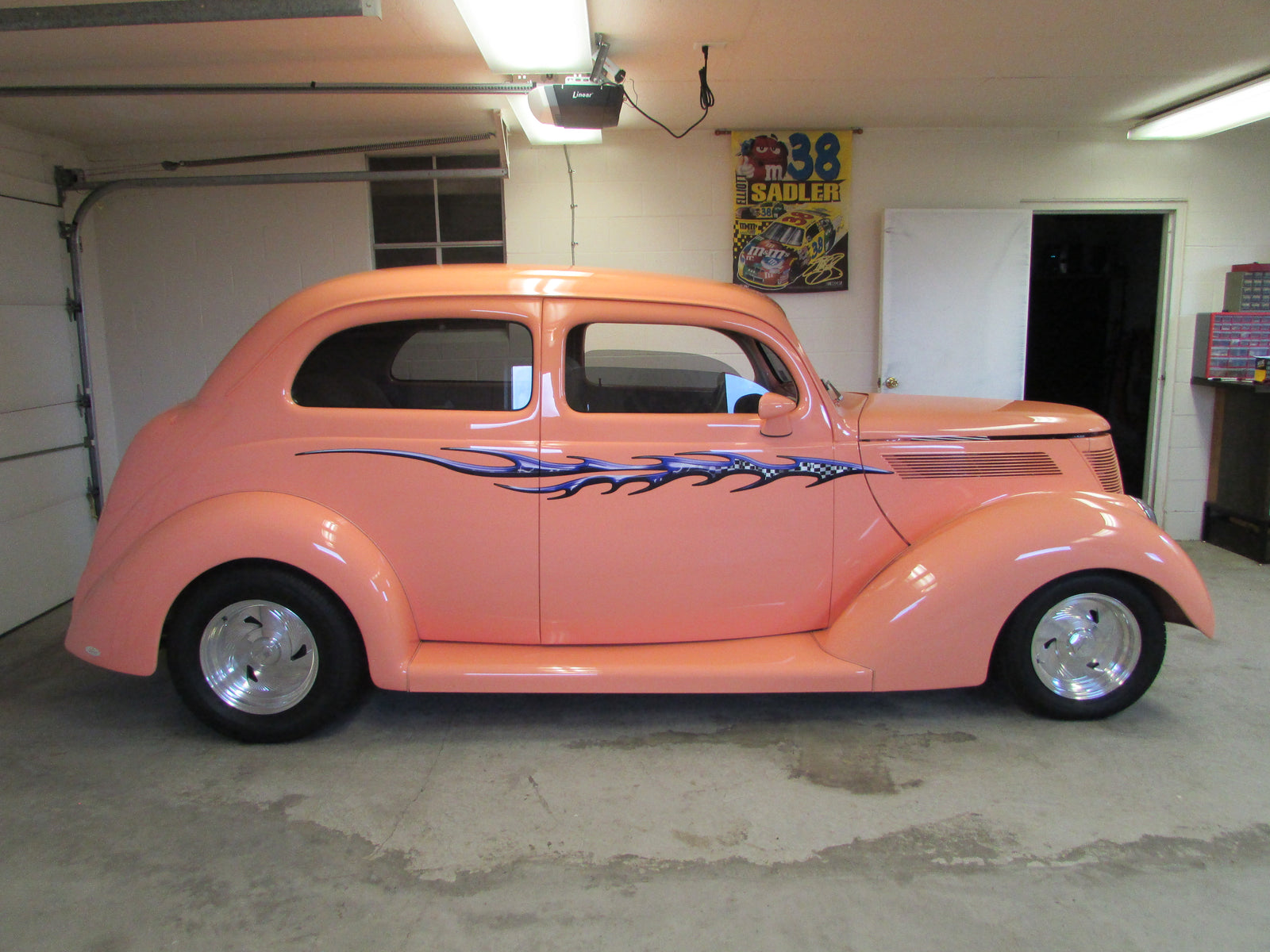 chrome racing decals on the side of a pink classic car