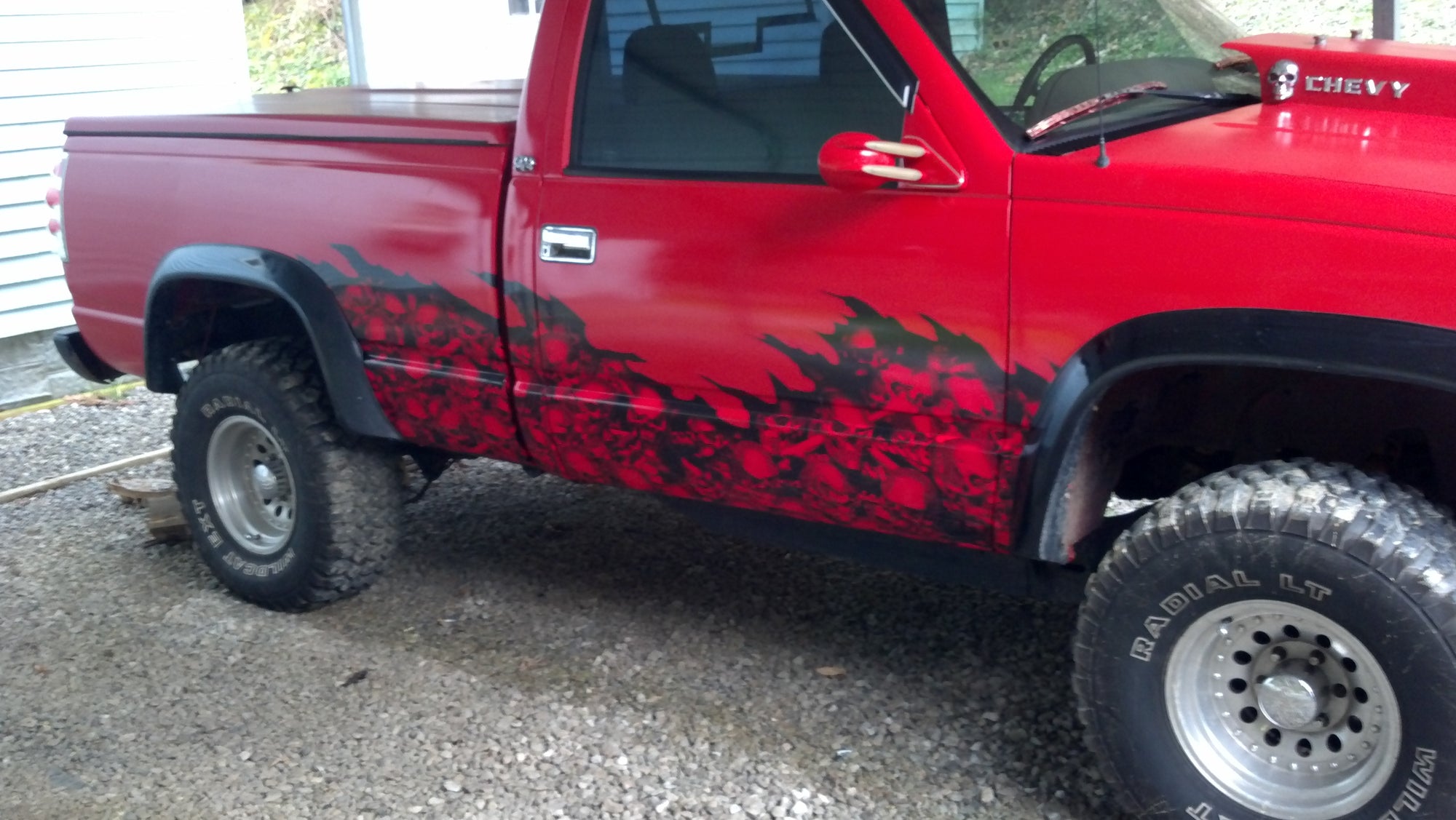 red wave of skulls vinyl half wrap decal on the bottom half of a red pick up truck
