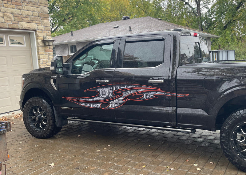 Customer-installed tribal steampunk decals on black pickup truck doors and bedside