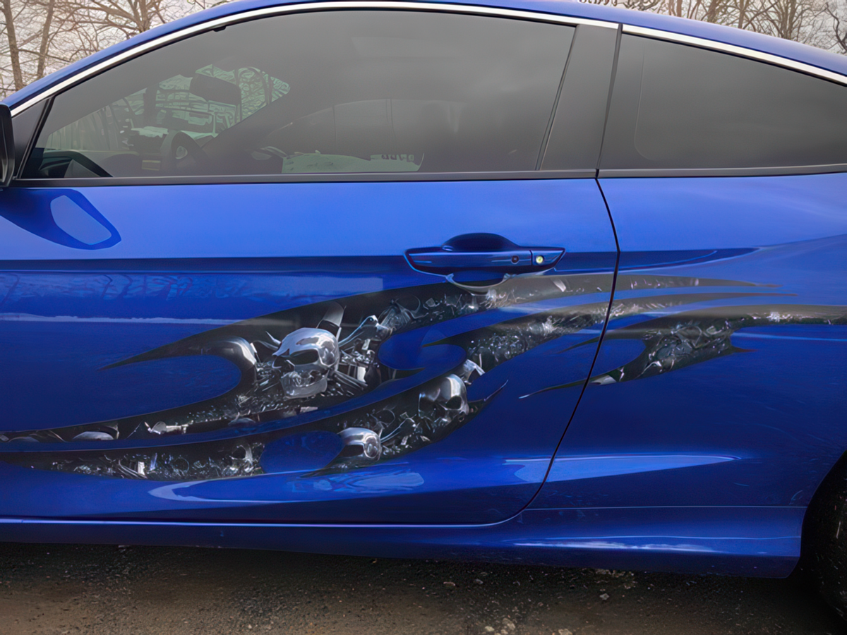 tribal chrome skulls vinyl graphics on the side of blue car