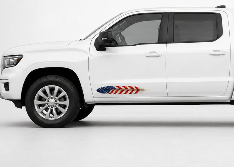 White pickup truck in driver-side profile with a small American flag feather decal on the lower front door.