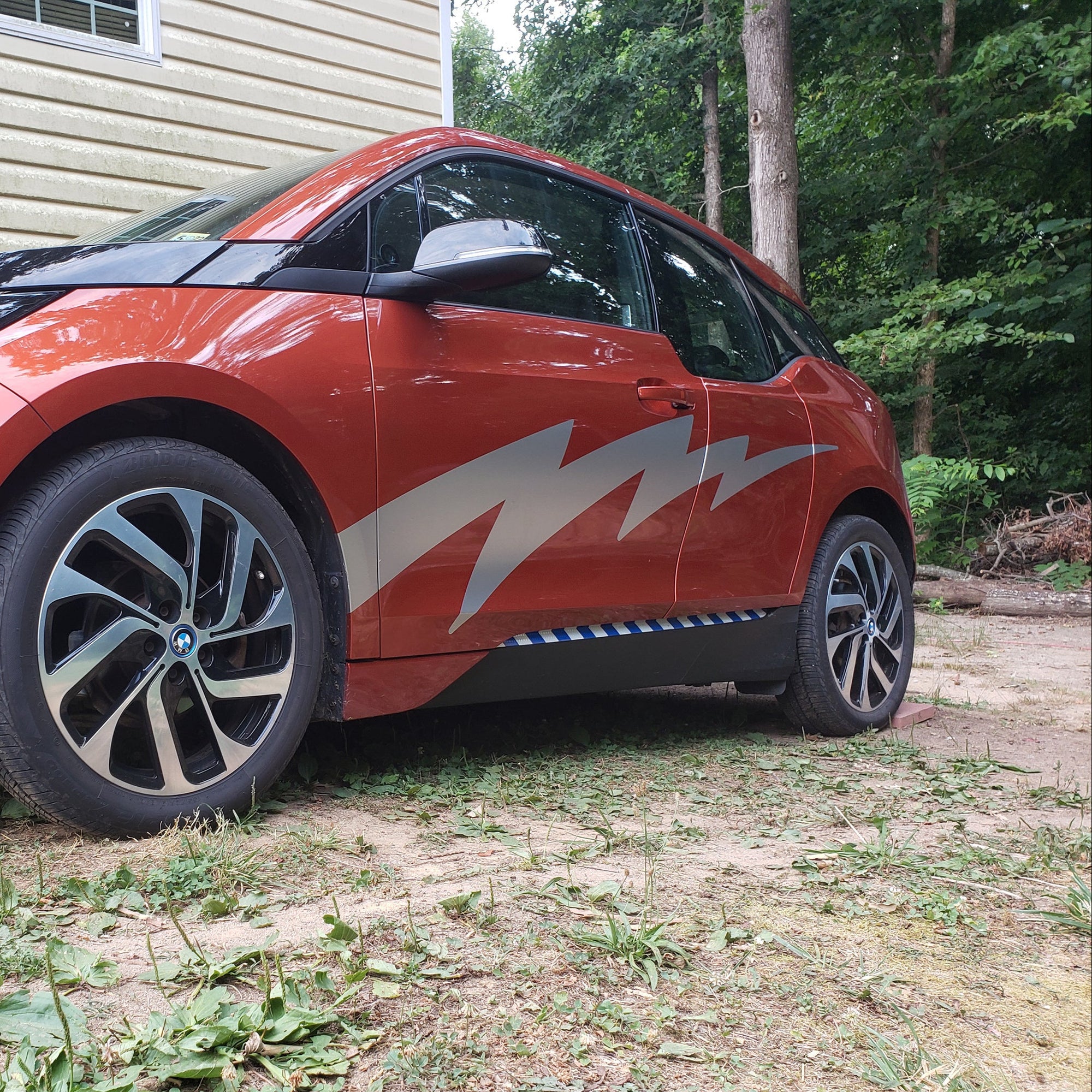 lightning bolt vinyl silver decal on the side of red bmw electric car