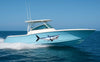 mako shark large vinyl graphics on the side of cruising boat in the water, the mako shark has its mouth showing it sharp teeth.
