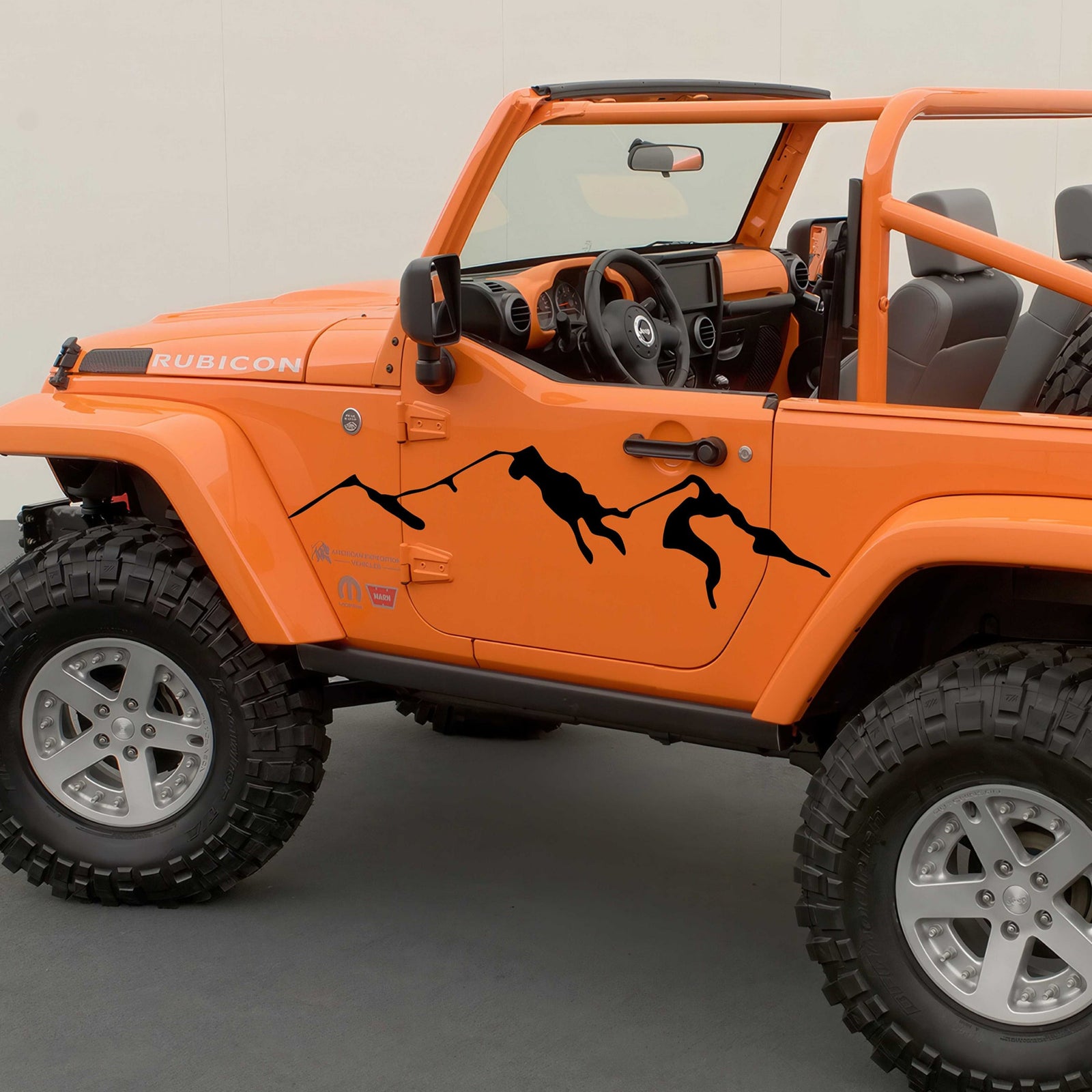 Orange off-road Rubicon Jeep with black mountain decals on its side
