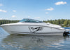 White boat with a black wolf vinyl decal on hull, on a calm body of water with trees in the background
