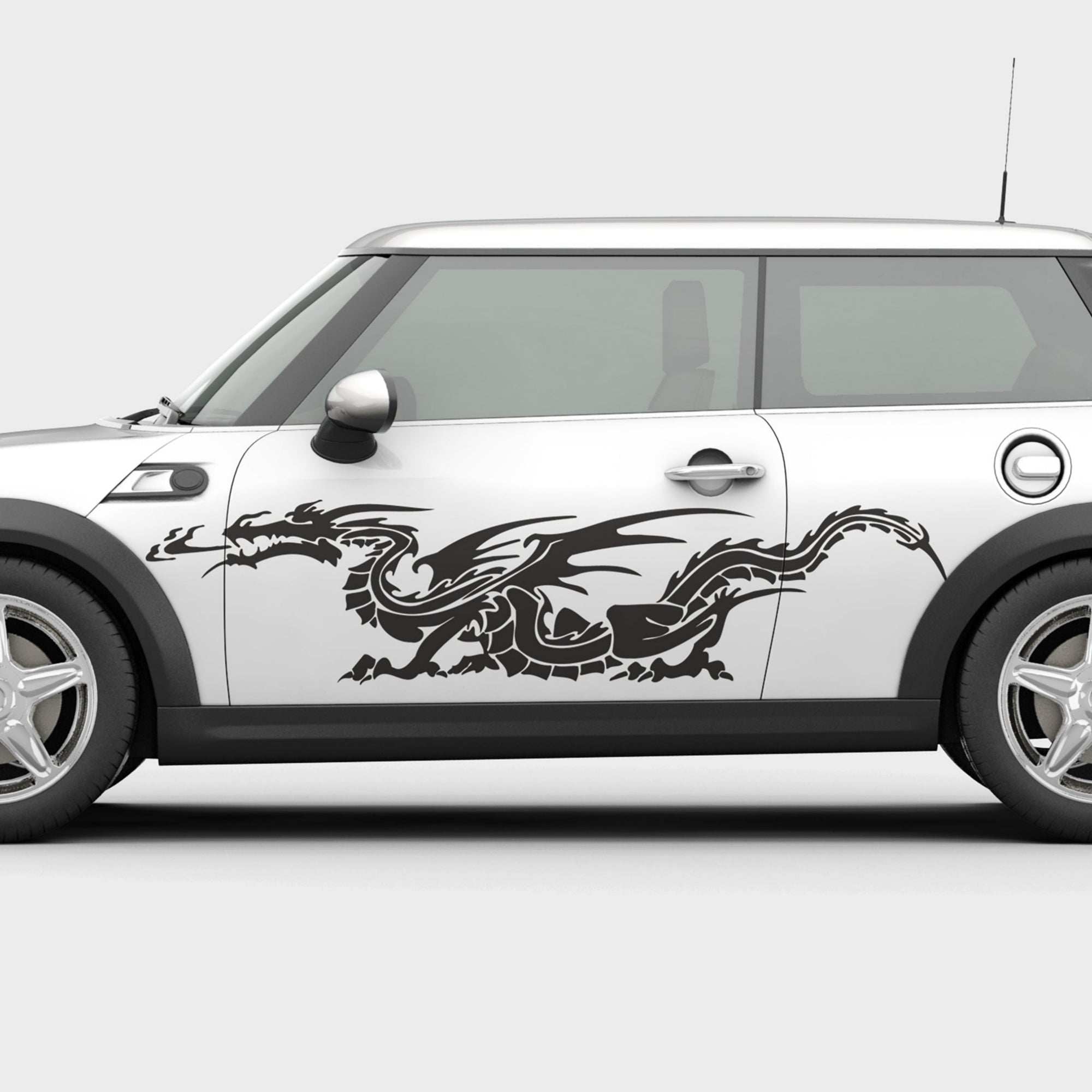 Black car with a neon green western dragon decal on its side parked on street