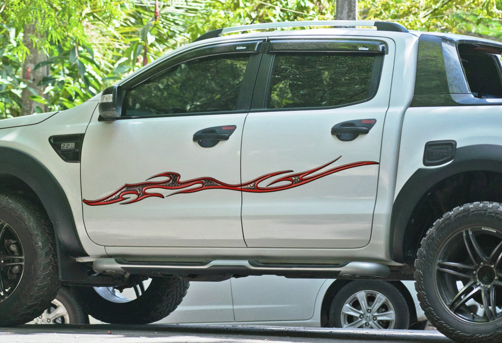 white truck with tempest diamond plate flame decal on driver side