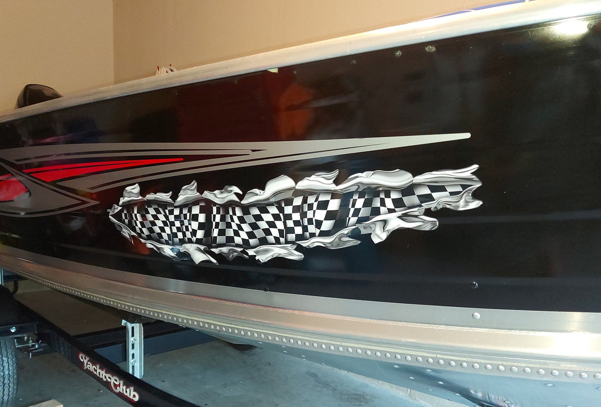Black boat on trailer parked in garage with checkered flag chrome tear decal on starboard side