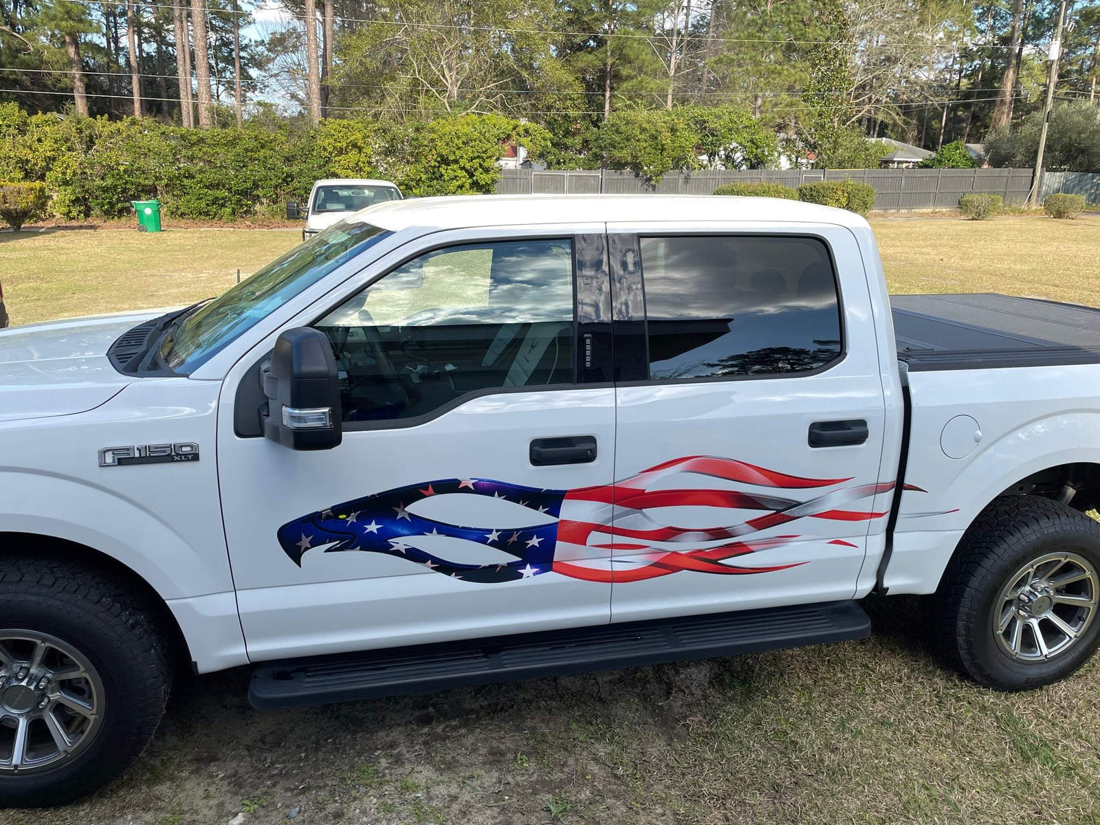 white GMC truck with eagle flames American flag on its passenger side