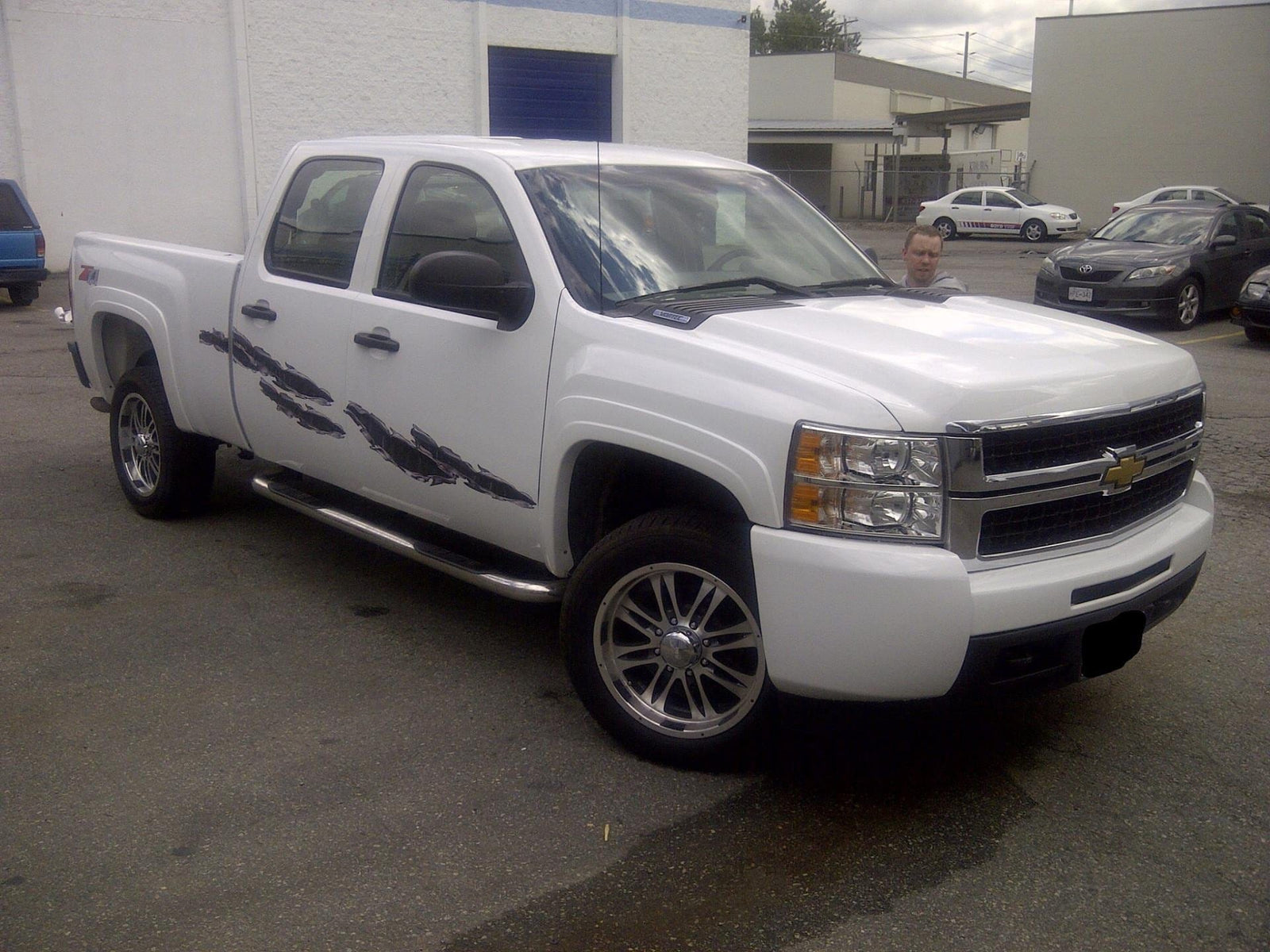 white truck with carbon fiber rip chrome vinyl graphics on driver side