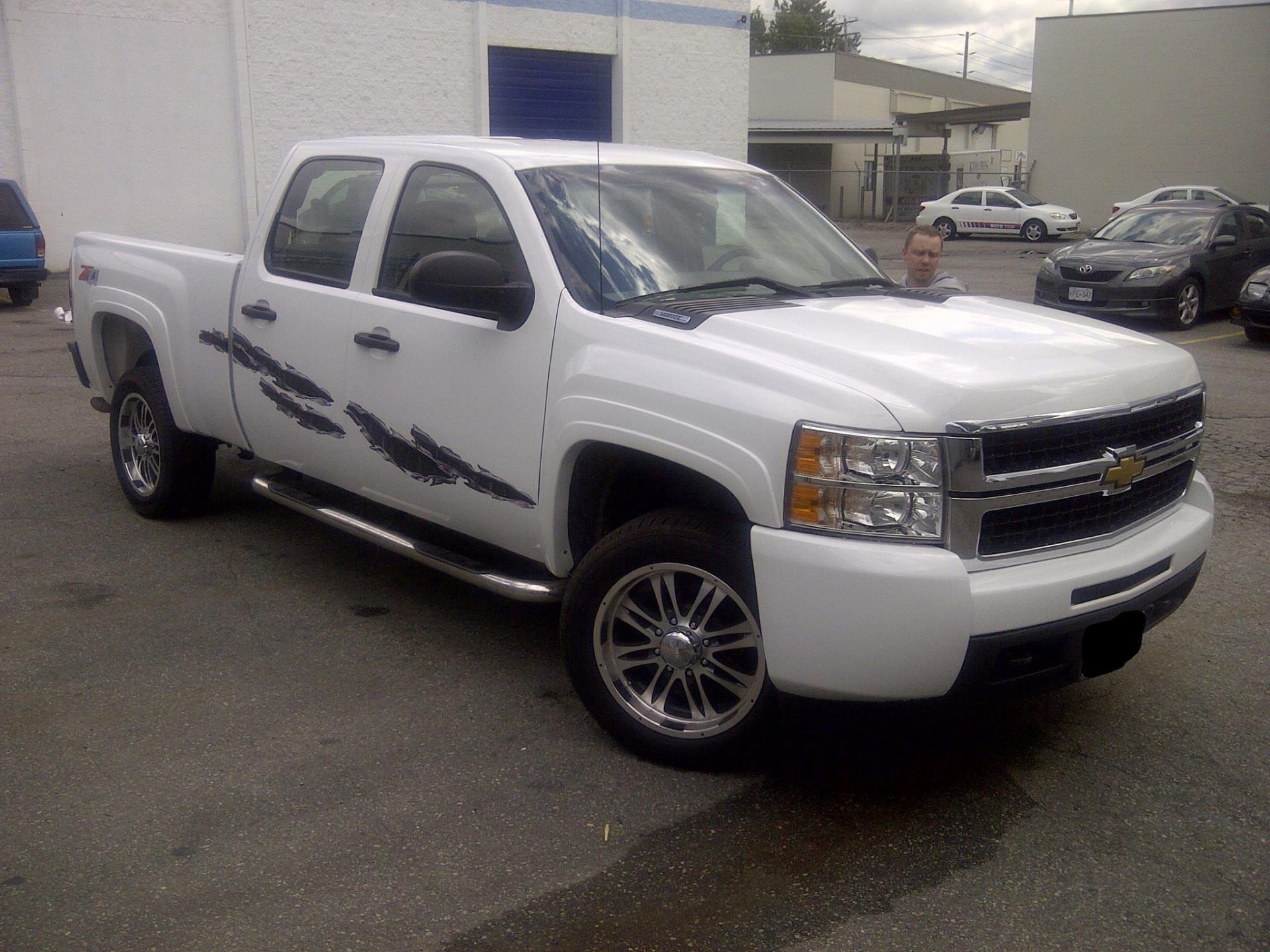 white truck with carbon fiber rip chrome vinyl graphics on driver side