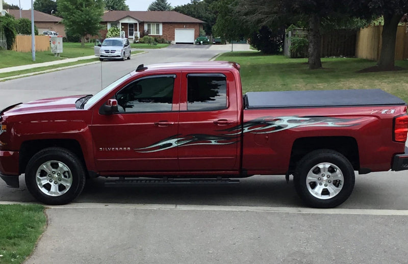 red silverado dully truck parked on street with grey tribal chains large decal on its driver side