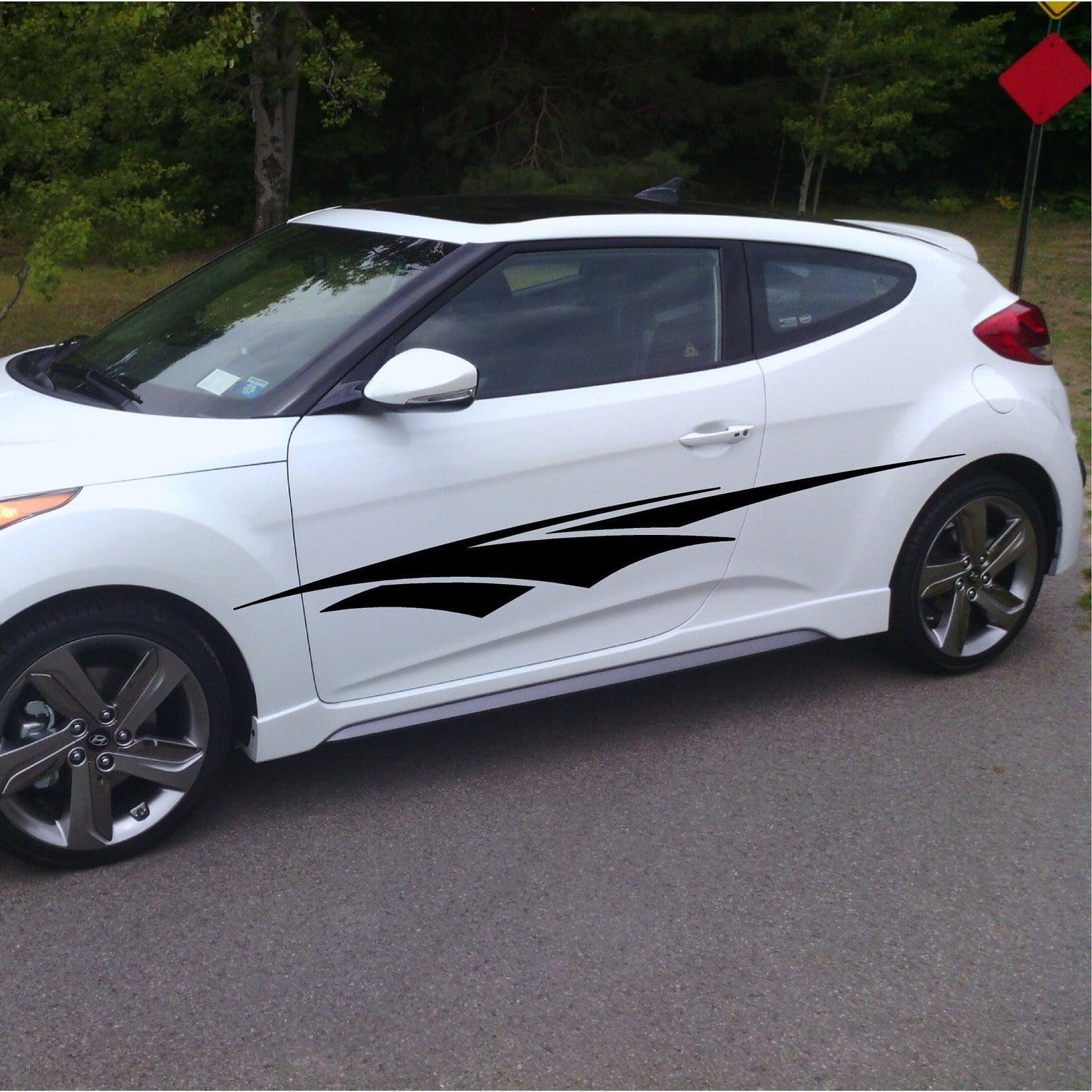 Side view of a white pickup truck with black spear decals on a white background