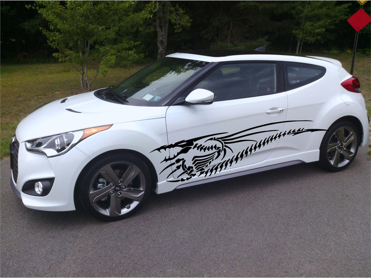 white hatchback car with black dragon skeleton vinyl graphics on driver side