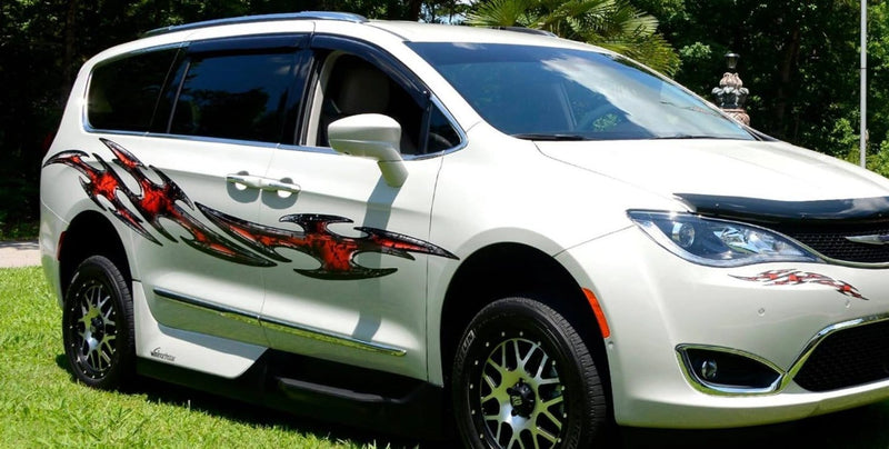 white mini van with red tribal flares  vinyl graphics across its passenger side .