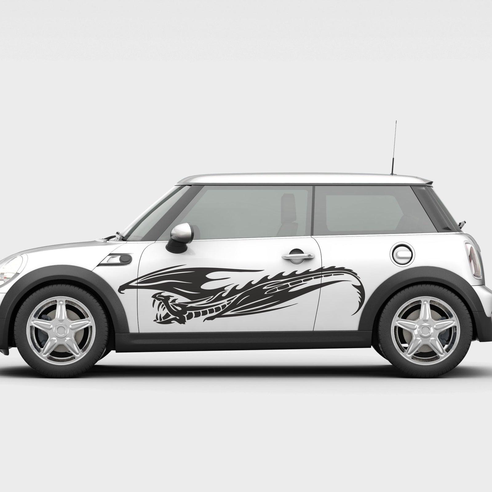 A car with a white body and a vinyl cut decal of a flying dragon graphic on the side door.